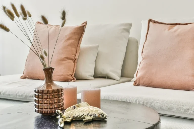 The furnishings are key in this Raleigh interior design project. Raleigh interior designers carefully placed the pink and tan pillows on the couch and added faux rice grass.