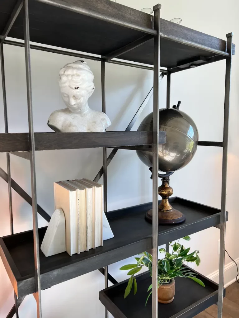 Interior design trinkets are strategically placed. Features include a globe, a figure, and books which were carefully placed by our Raleigh interior designers.